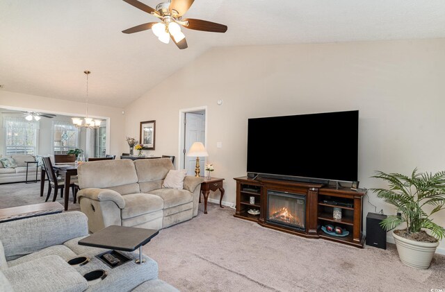 living room with carpet floors, baseboards, ceiling fan with notable chandelier, and lofted ceiling