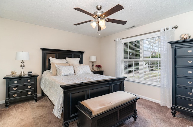 bedroom with carpet flooring, ceiling fan, a textured ceiling, baseboards, and visible vents