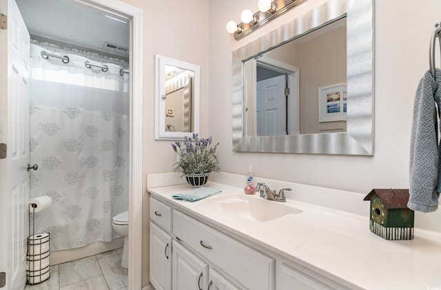 bathroom with toilet, marble finish floor, and vanity