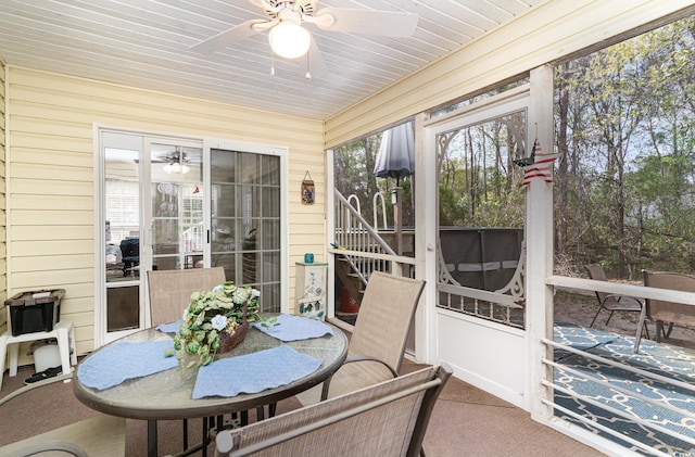 sunroom / solarium with a ceiling fan and outdoor dining area