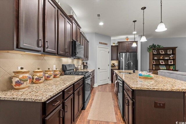 129 Astoria Park Loop, Conway, SC 29526 - kitchen with stainless steel appliances, light wood-style floors, a kitchen bar, visible vents, and dark brown cabinets