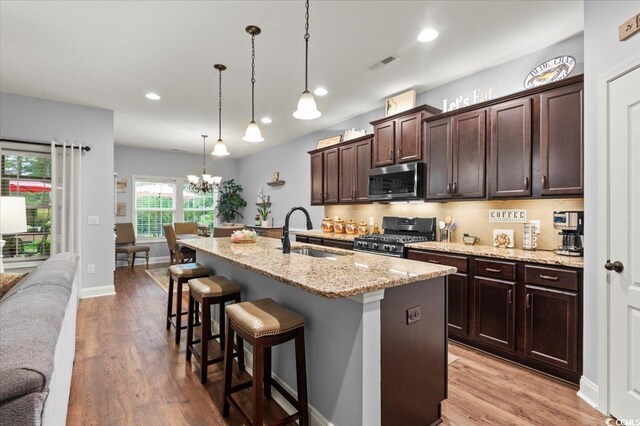 129 Astoria Park Loop, Conway, SC 29526 - kitchen with light stone countertops, a sink, pendant lighting, wood finished floors, and ceiling fan with notable chandelier
