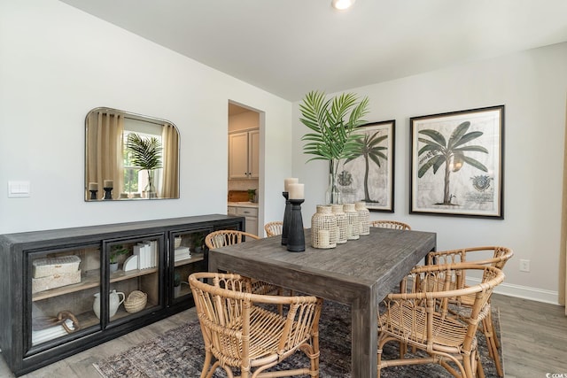 dining space featuring baseboards and wood finished floors