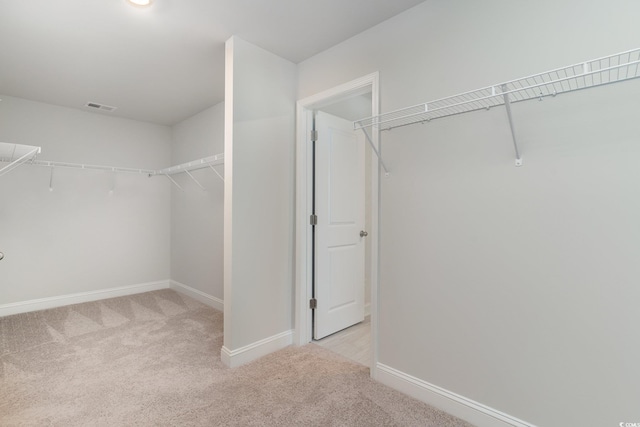 walk in closet with visible vents and carpet flooring