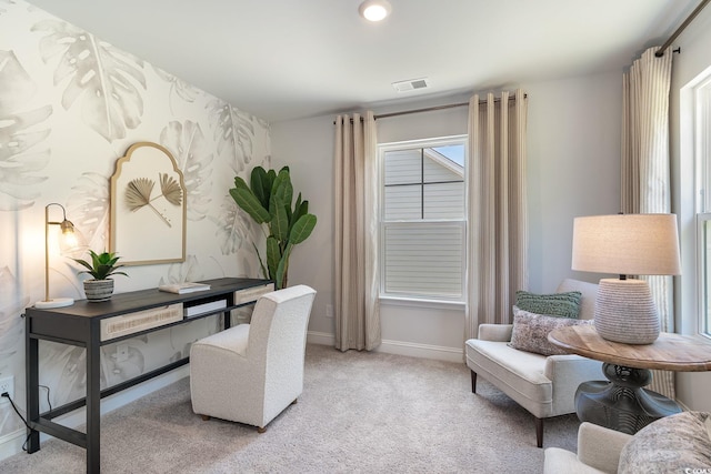 office area featuring baseboards, visible vents, and light carpet