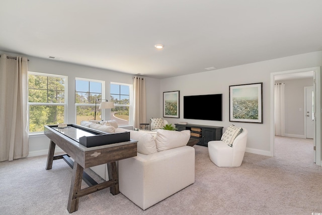 living room featuring visible vents, a wealth of natural light, and light carpet