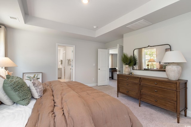 bedroom with light colored carpet, baseboards, visible vents, and a raised ceiling