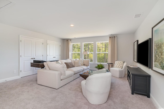 living room featuring carpet floors, baseboards, and visible vents