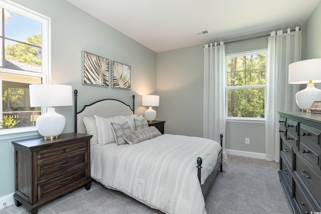 bedroom with baseboards, light colored carpet, and visible vents