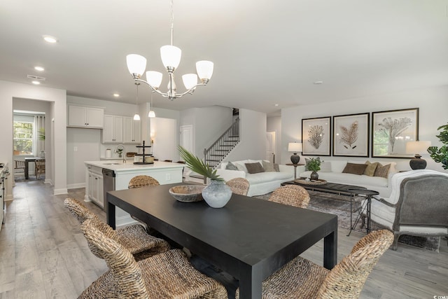 dining area with a notable chandelier, stairs, recessed lighting, baseboards, and light wood-type flooring