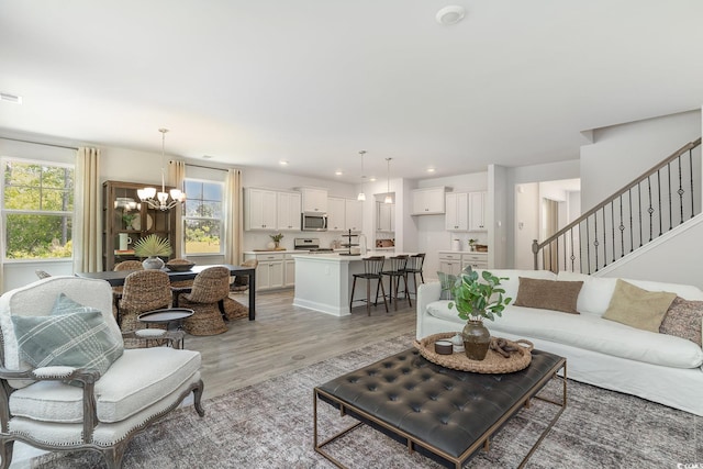 living room featuring a notable chandelier, light wood-style floors, stairs, recessed lighting, and visible vents