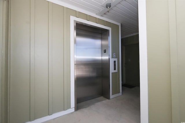 hallway with concrete flooring and elevator