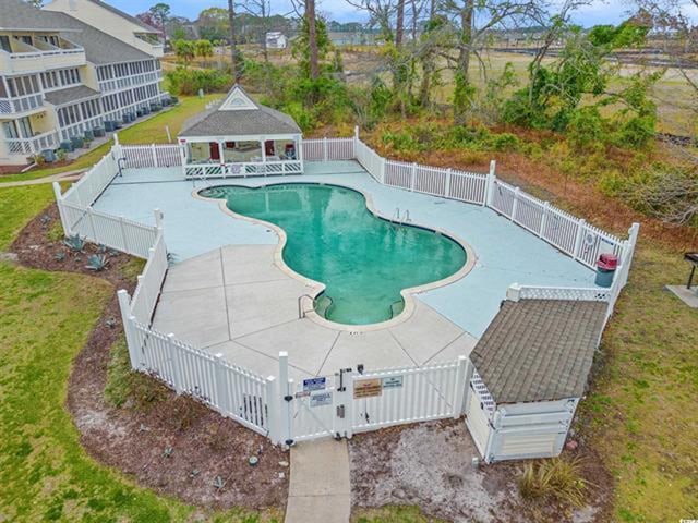 view of swimming pool with a yard and fence private yard