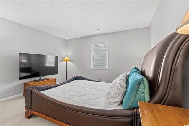 bedroom featuring a textured ceiling, carpet floors, and baseboards