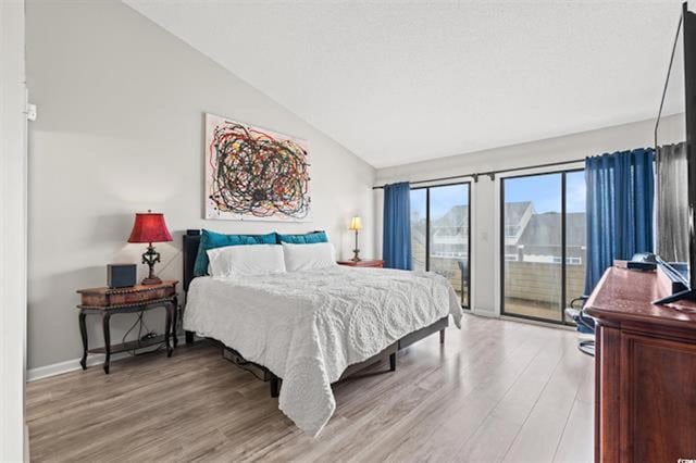 bedroom with lofted ceiling, baseboards, light wood-style flooring, and access to exterior