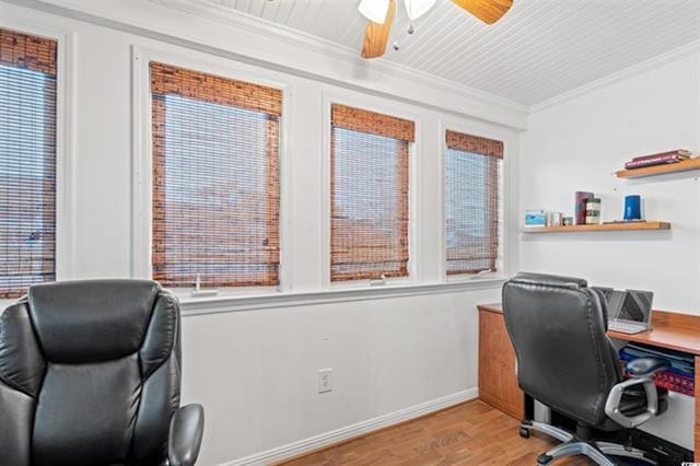 office space featuring wood finished floors, ornamental molding, a ceiling fan, plenty of natural light, and baseboards