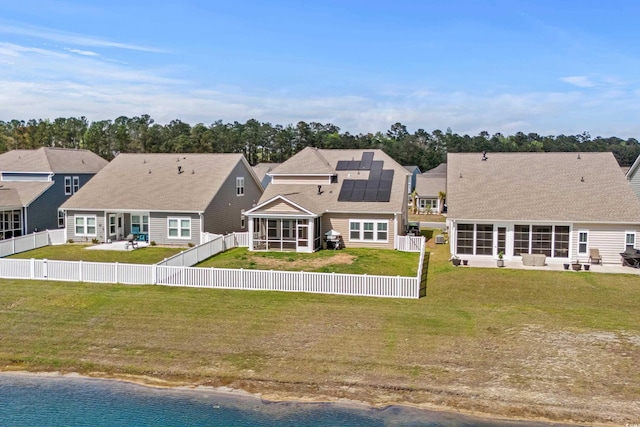 852 Harrison Mill St, Myrtle Beach, SC 29579 - rear view of house with a sunroom, solar panels, a fenced backyard, and a water view