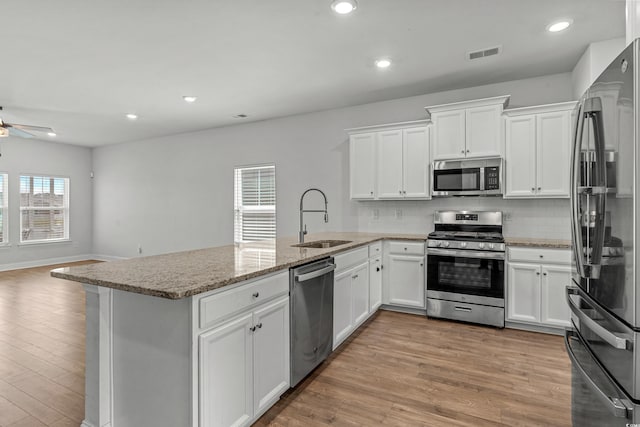 852 Harrison Mill St, Myrtle Beach, SC 29579 - kitchen with appliances with stainless steel finishes, a peninsula, a ceiling fan, decorative backsplash, and light stone countertops