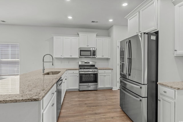 852 Harrison Mill St, Myrtle Beach, SC 29579 - kitchen featuring appliances with stainless steel finishes, white cabinets, light wood finished floors, a peninsula, and recessed lighting