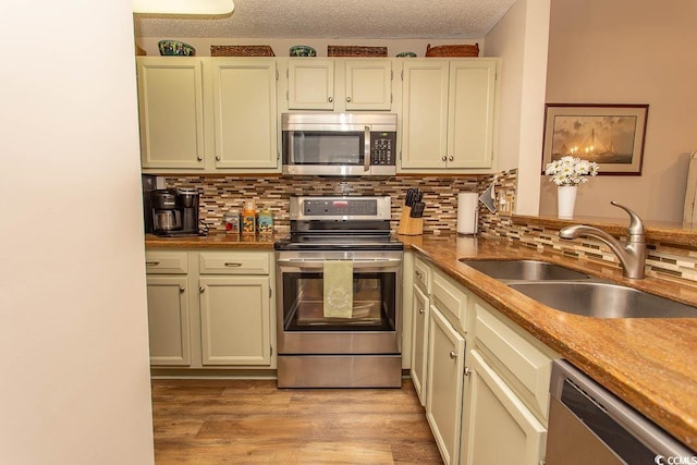 1221 Tidewater Dr Unit 1922, North Myrtle Beach, SC 29582 - kitchen featuring stainless steel appliances, a sink, decorative backsplash, and light wood-style floors
