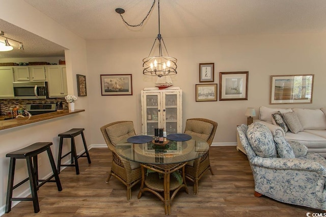1221 Tidewater Dr Unit 1922, North Myrtle Beach, SC 29582 - dining room with dark wood finished floors, a textured ceiling, a chandelier, and baseboards