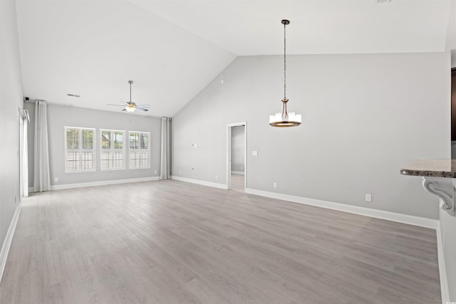 unfurnished living room with high vaulted ceiling, baseboards, light wood finished floors, visible vents, and ceiling fan
