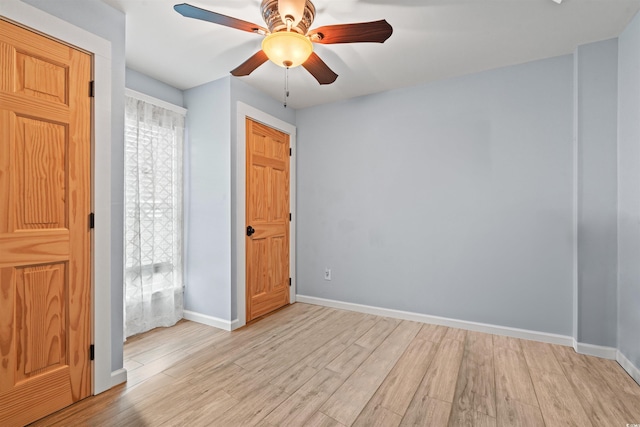 unfurnished bedroom featuring baseboards, a ceiling fan, and light wood-type flooring