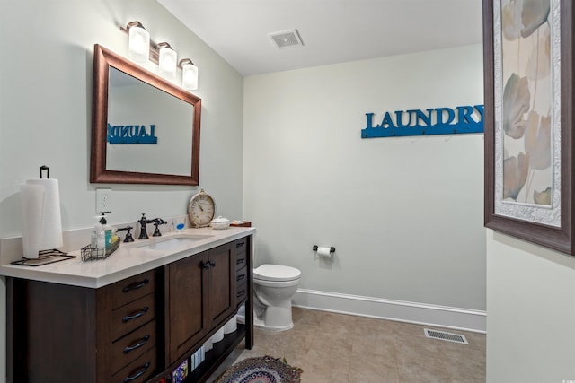 bathroom with vanity, baseboards, toilet, and visible vents