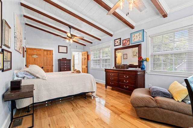 bedroom with baseboards, vaulted ceiling with beams, a ceiling fan, and light wood finished floors