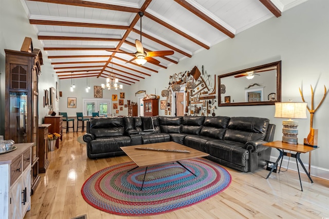 living room featuring a ceiling fan, lofted ceiling with beams, and light wood finished floors