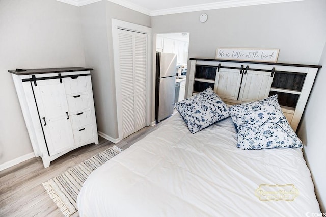 2001 S Ocean Blvd S Unit 310, Myrtle Beach, SC 29577 - bedroom featuring freestanding refrigerator, crown molding, light wood finished floors, baseboards, and a closet
