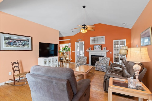 808 Arbor Ln, North Myrtle Beach, SC 29582 - living area featuring light wood-type flooring, vaulted ceiling, ceiling fan, and a tiled fireplace