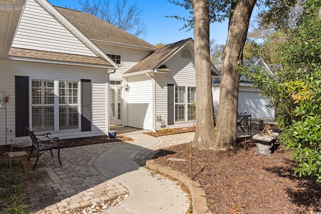 808 Arbor Ln, North Myrtle Beach, SC 29582 - rear view of house featuring roof with shingles and a patio