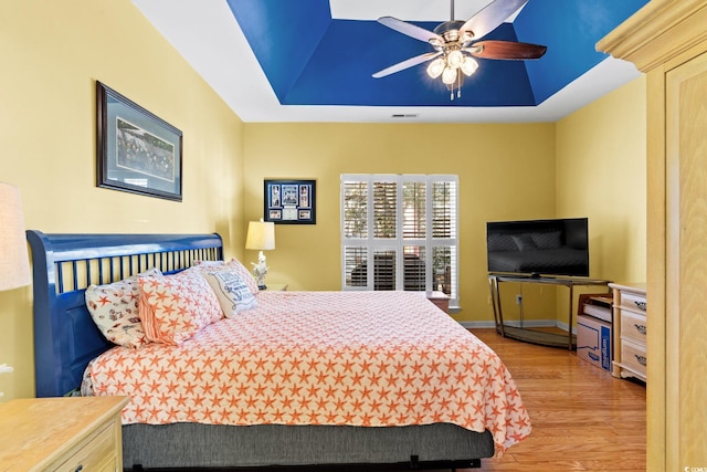 808 Arbor Ln, North Myrtle Beach, SC 29582 - bedroom with wood finished floors, a tray ceiling, and a ceiling fan