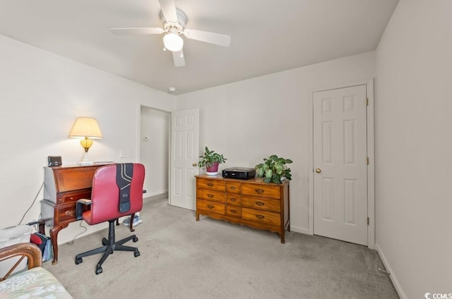 carpeted office featuring baseboards and a ceiling fan