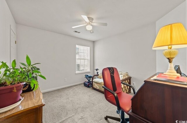 carpeted office space featuring baseboards, ceiling fan, and visible vents