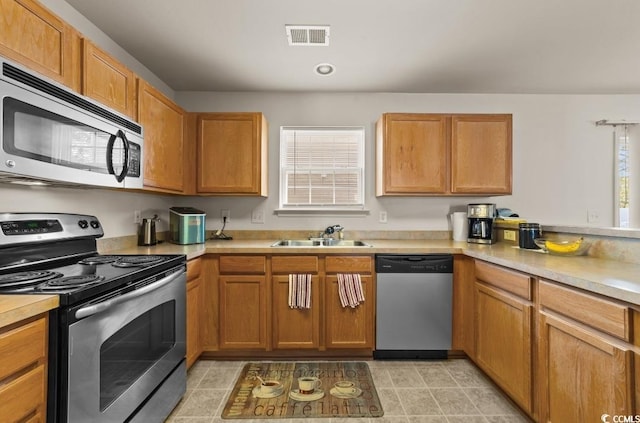 kitchen with light countertops, a sink, stainless steel appliances, and visible vents