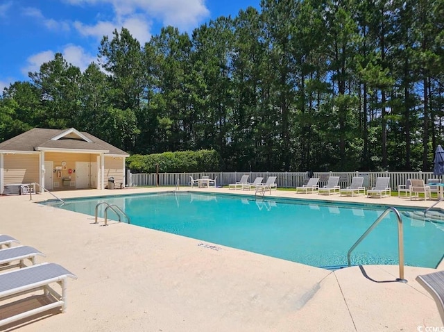 community pool featuring fence and a patio