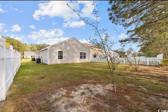 back of property featuring central air condition unit, fence, and a yard