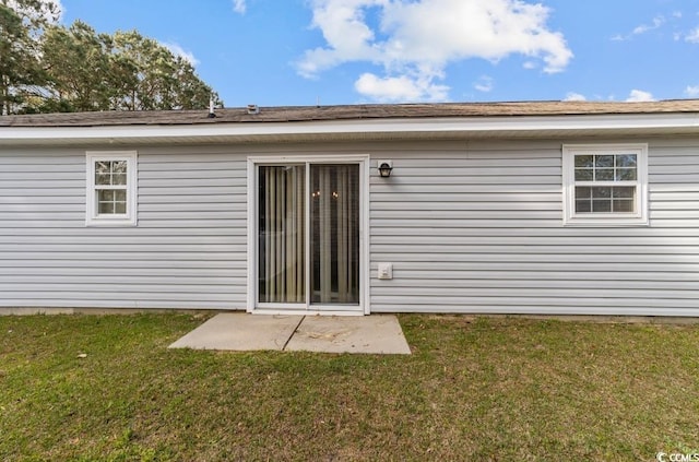 back of house with a patio area and a lawn