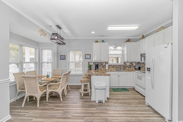 6001-310 S Kings Hwy, Myrtle Beach, SC 29575 - kitchen with white appliances, white cabinets, a peninsula, light wood-style floors, and ornamental molding