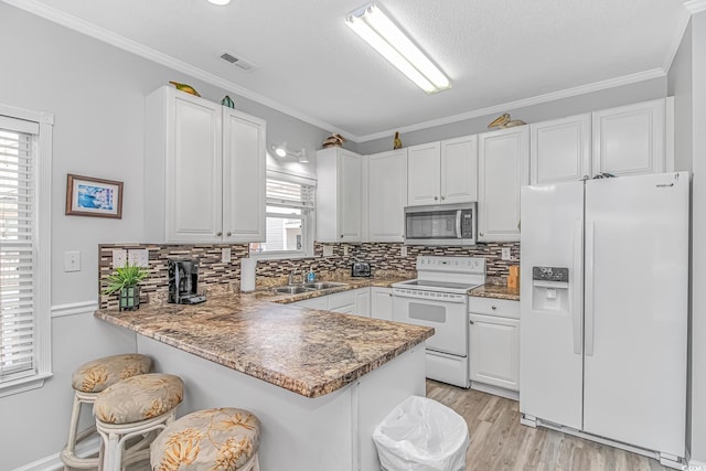 6001-310 S Kings Hwy, Myrtle Beach, SC 29575 - kitchen with white appliances, a sink, a peninsula, decorative backsplash, and a breakfast bar area