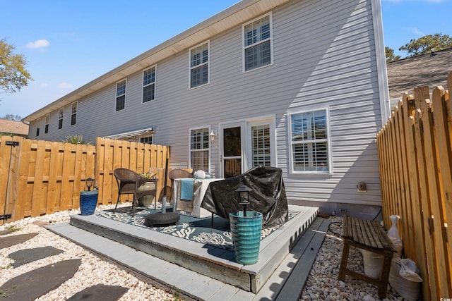 rear view of house featuring a fenced backyard