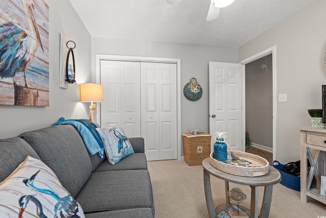 living area with a ceiling fan and light carpet
