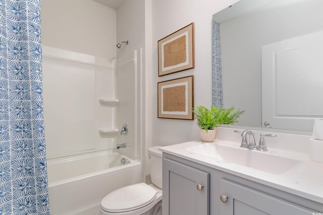 bathroom featuring toilet, vanity, and  shower combination