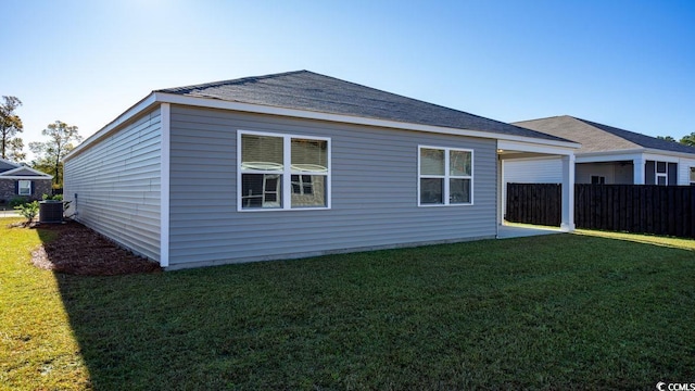 back of property with central AC unit and a shingled roof