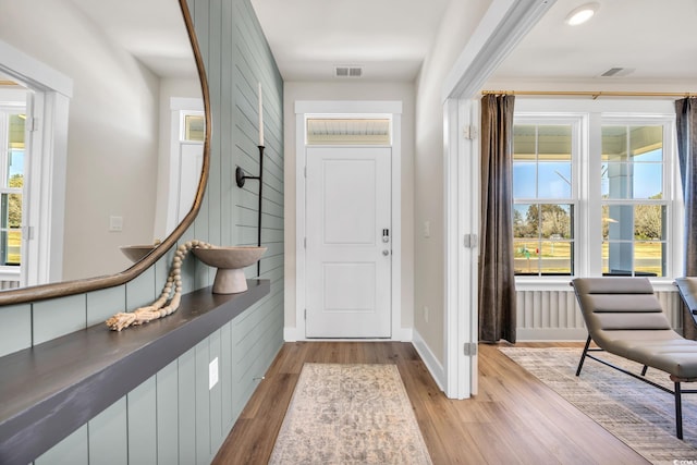 entryway featuring light wood-style flooring, baseboards, and visible vents