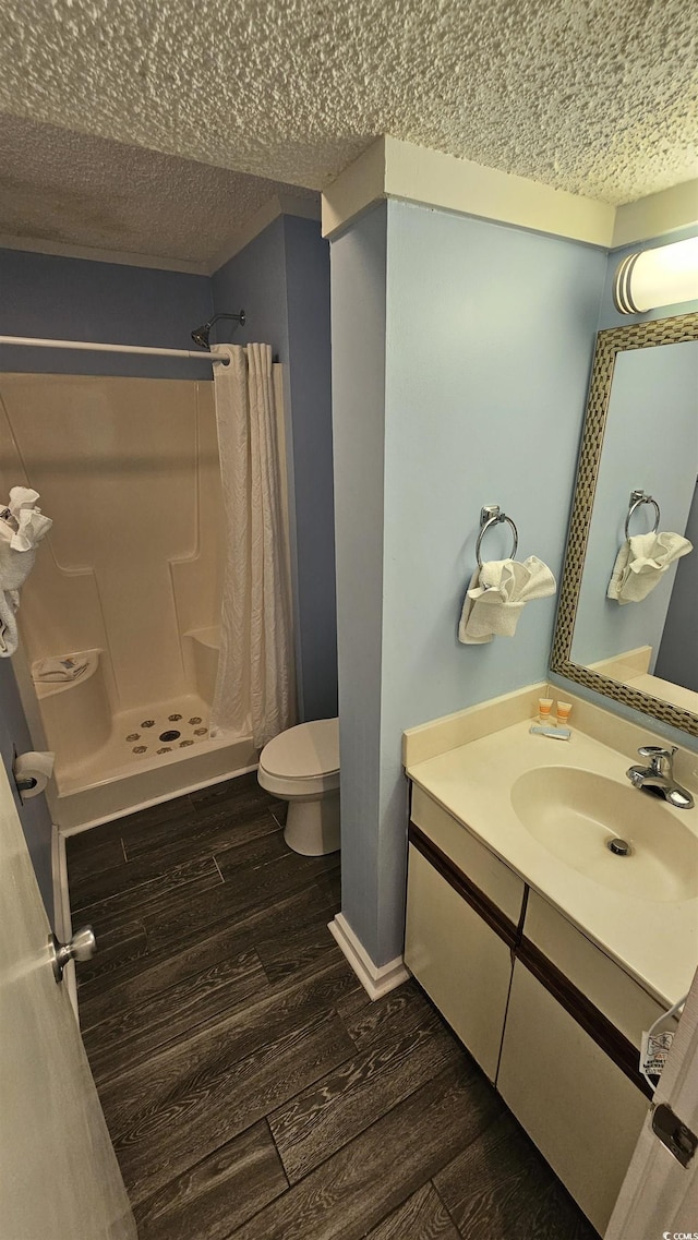 415 Ocean Creek Dr Unit 2443, Myrtle Beach, SC 29572 - full bathroom featuring wood finished floors, a shower stall, a textured ceiling, toilet, and vanity