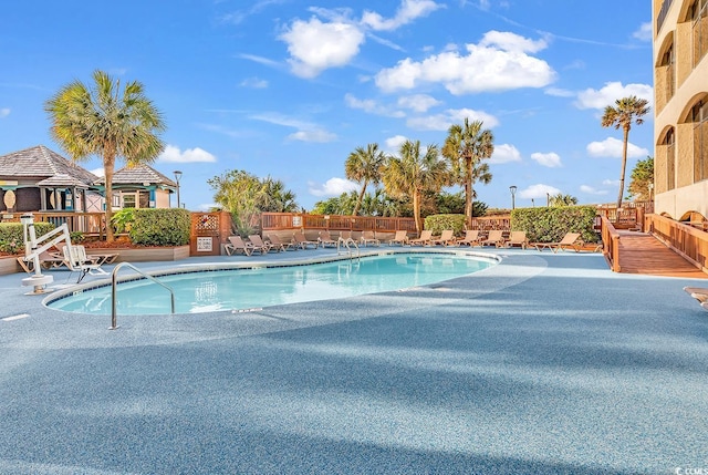 pool with fence and a patio