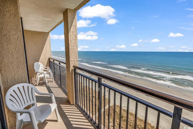 balcony featuring a water view and a beach view